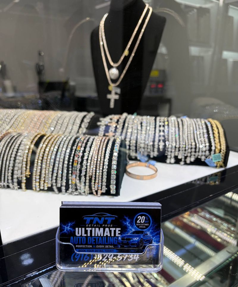 A TNT Detail Pros card in a holder in front of a jewelry display case at Crown Jewelers in Arden Mall