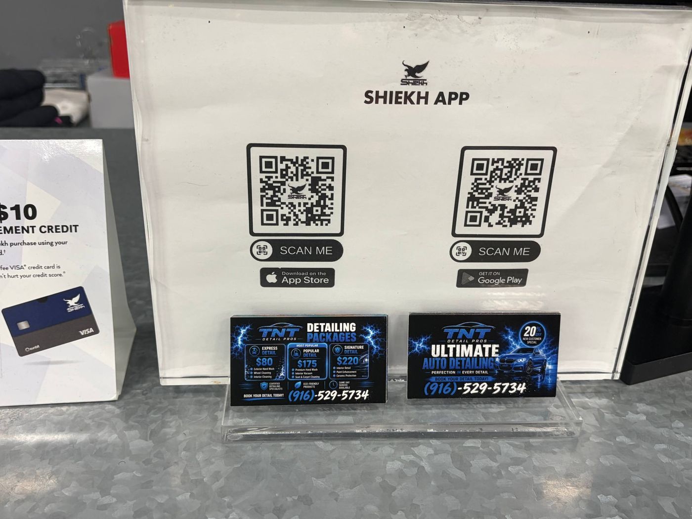 Two TNT Detail Pros business cards displayed at the Shiekh counter